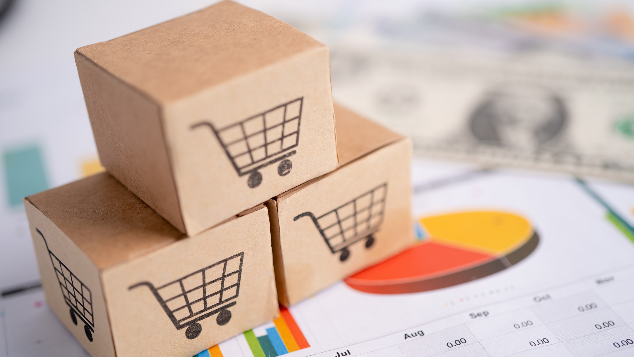 Parcel boxes with shopping cart icons stacked on financial charts
