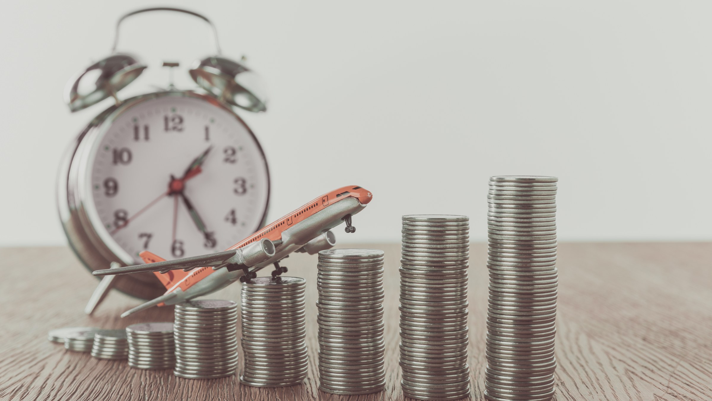 Alarm clock beside rising stacks of coins representing CAC payback time