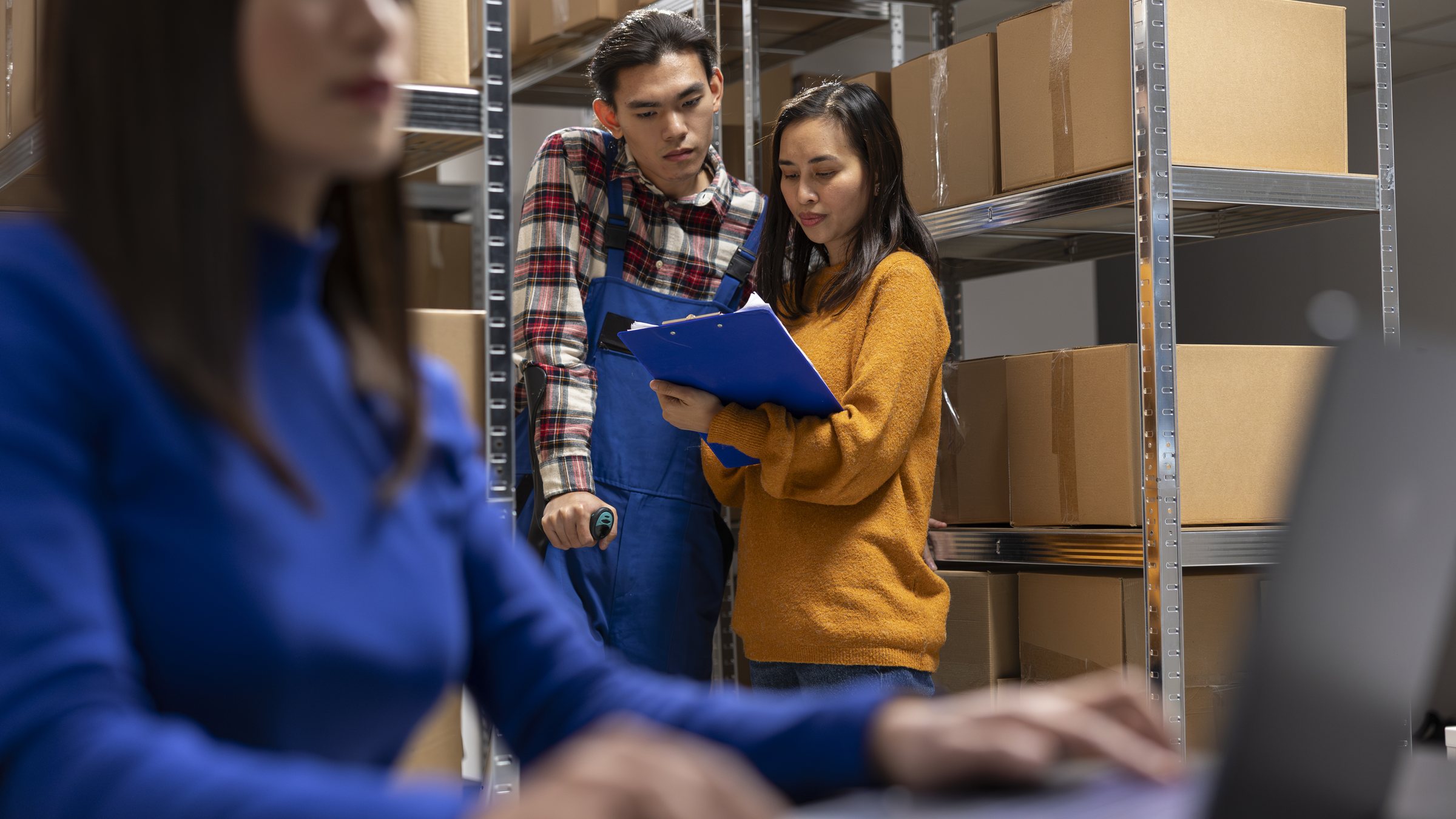 Operations team checking inventory among warehouse shelves