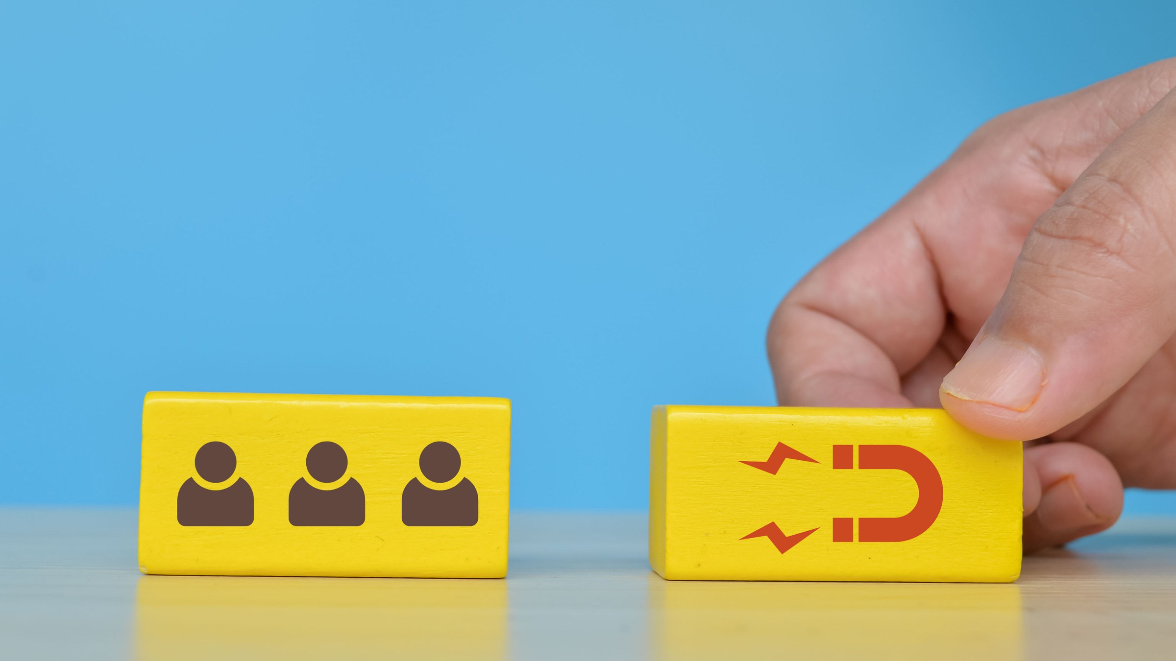Wooden blocks with people icons being sorted, lead scoring concept